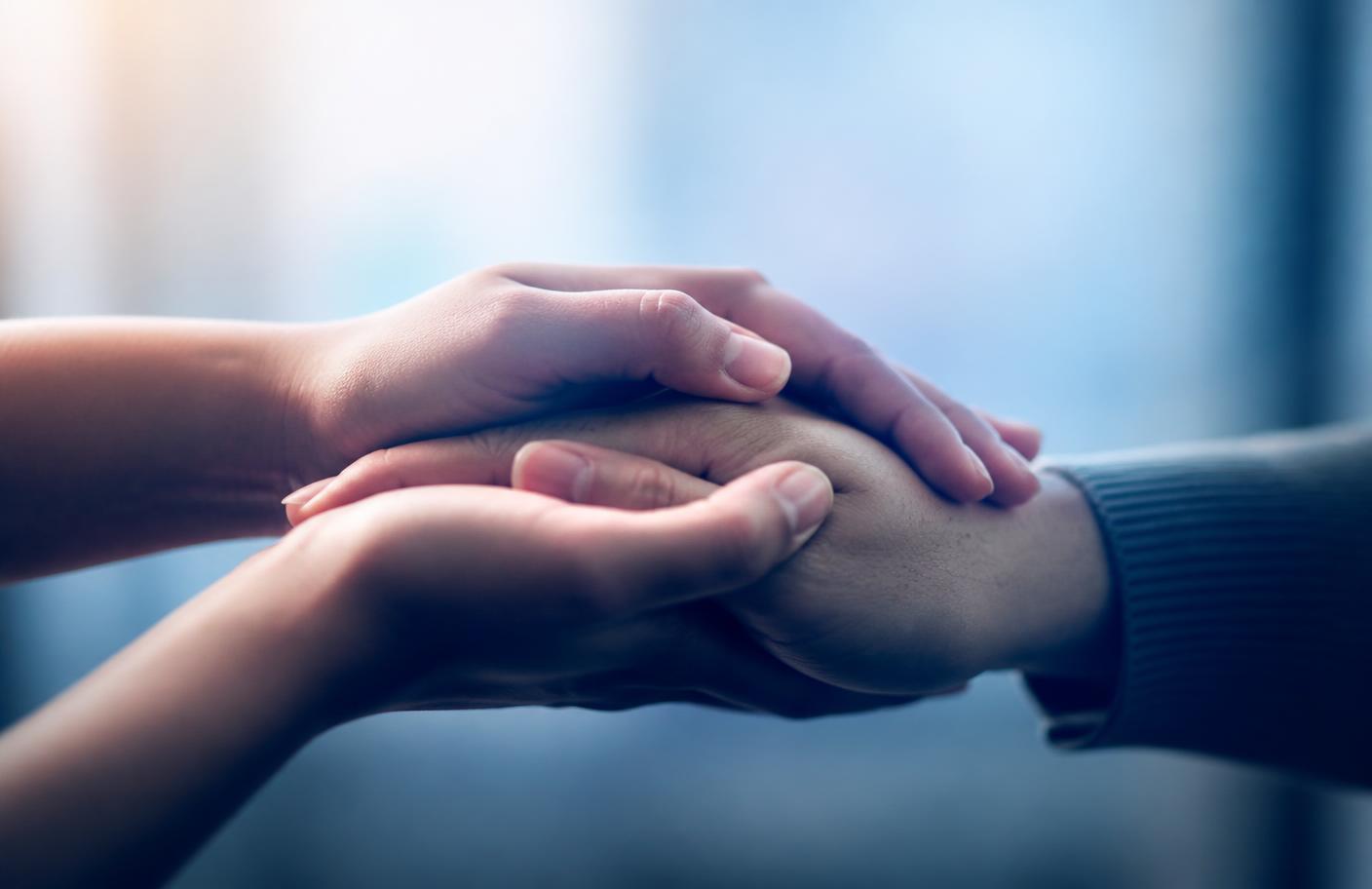 Mãos unidas em gesto de acolhimento